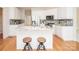 Kitchen island boasts seating, granite counters, stainless appliances, and modern cabinetry at 2019 Heirloom Ct, Matthews, NC 28104