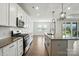Open-concept kitchen with granite island, stainless appliances, white cabinets and hardwood floors, offering ample space at 231 Cotton Ridge Pl, Rock Hill, SC 29730