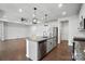 Spacious kitchen island with granite countertops, stainless steel appliances, and pendant lights, overlooking the living area at 231 Cotton Ridge Pl, Rock Hill, SC 29730