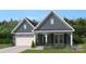 Charming home featuring gray siding, a stone-accented garage, and a cozy front porch at 3061 Bent Willow Dr, Indian Trail, NC 28079