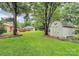 Well-maintained backyard with a shed, garage, and mature trees at 3304 Chilham Pl, Charlotte, NC 28226