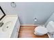 Bathroom with white cabinets, single sink vanity, and wood-look flooring at 3304 Chilham Pl, Charlotte, NC 28226