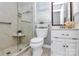 Bathroom featuring walk-in shower with glass door, updated fixtures, and white vanity at 3304 Chilham Pl, Charlotte, NC 28226