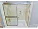 Bathroom with a shower-tub featuring glass doors and built-in shelving at 3304 Chilham Pl, Charlotte, NC 28226