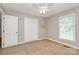 Empty bedroom with a ceiling fan, window, and double closet at 3304 Chilham Pl, Charlotte, NC 28226