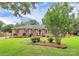 A well-manicured front lawn leads to a charming brick house with a red front door and blue shutters at 3304 Chilham Pl, Charlotte, NC 28226