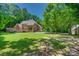Backyard of a brick house has a patio, lush greenery and a large yard at 413 Farm Branch Dr, Fort Mill, SC 29715
