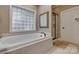 Bathroom featuring a soaking tub, glass block window, and glass shower enclosure at 413 Farm Branch Dr, Fort Mill, SC 29715