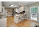 Bright kitchen featuring a granite island, stainless steel appliances, and light wood floors at 413 Farm Branch Dr, Fort Mill, SC 29715