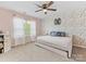 Light-filled bedroom with a daybed, floral accent wall, and soft pink walls at 4261 Coachwhip Ave, Lancaster, SC 29720