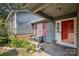 Welcoming front porch with sitting area, red door, and vibrant flower garden at 432 English Ivy Ct, Fort Mill, SC 29715