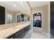 Luxurious bathroom featuring marble countertops, dual sinks, and access to a walk-in closet at 435 S Tryon St # 907, Charlotte, NC 28202