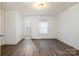 Bedroom with wood floors, neutral color palette and a bathroom with white fixtures attached at 4510 Wildwood Ave, Charlotte, NC 28208