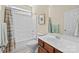 Clean bathroom with a shower-tub combo, vanity with wooden cabinets, and a well-lit mirror at 4527 Hubbard Falls Dr, Charlotte, NC 28269
