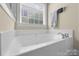 Bathtub features tile surround, chrome fixtures and natural light at 4527 Hubbard Falls Dr, Charlotte, NC 28269