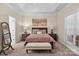 Well-lit bedroom featuring a large bed, bench, and tray ceiling at 4527 Hubbard Falls Dr, Charlotte, NC 28269