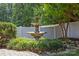 Backyard features a stone fountain, mature trees, and manicured landscaping at 4527 Hubbard Falls Dr, Charlotte, NC 28269