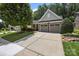 Charming home featuring a well-manicured lawn, mature trees, and a two-car garage, enhancing its curb appeal at 4527 Hubbard Falls Dr, Charlotte, NC 28269