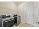 Bright laundry room features a modern washer and dryer, tile floors, and access to the outside at 4527 Hubbard Falls Dr, Charlotte, NC 28269