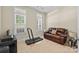 Cozy sitting room featuring ample sunlight, a comfortable leather couch, and neutral carpeting at 4527 Hubbard Falls Dr, Charlotte, NC 28269