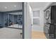 Clean laundry area with stacked washer and dryer, artwork, and a glimpse into a home gym at 498 Glory Ct, Fort Mill, SC 29715