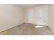 Neutral-toned carpeted bedroom featuring two white doors and plenty of open space at 5307 Ayers Orchard Way, Charlotte, NC 28227
