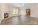 Open-concept living room features a fireplace and hardwood-style flooring with a glimpse of the kitchen at 5307 Ayers Orchard Way, Charlotte, NC 28227