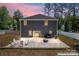 Stunning back exterior showcasing a grill, a fire pit, and a concrete patio surrounded by lush greenery at 6425 Pamela St, Huntersville, NC 28078
