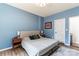 Comfortable bedroom featuring warm blue walls, hardwood flooring, and minimalist modern decor at 6425 Pamela St, Huntersville, NC 28078