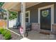 Cozy front porch with rocking chairs, brick accents, and a welcoming wreath on the black front door at 6425 Pamela St, Huntersville, NC 28078