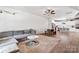 Open-concept living room with gray sectional, modern decor, and seamless flow into the adjacent kitchen area at 6425 Pamela St, Huntersville, NC 28078