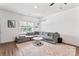 Bright living room with gray sectional sofa, area rug, large window, and modern cat shelves on the wall at 6425 Pamela St, Huntersville, NC 28078