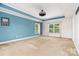 Spacious bedroom featuring large windows, a ceiling fan, and blue accent wall at 704 Millstream Dr, Rock Hill, SC 29732