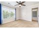 This carpeted bedroom features a ceiling fan, and a large window overlooking green trees at 704 Millstream Dr, Rock Hill, SC 29732