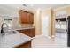 Kitchen featuring granite countertops, stainless sink, brown cabinetry, and tile flooring at 704 Millstream Dr, Rock Hill, SC 29732