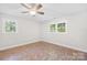Light-filled bedroom featuring a ceiling fan, wood-look floors, and two windows with views at 716 W Graham St, Shelby, NC 28150