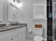 Well-lit bathroom boasts granite countertops, sleek fixtures, and a shower with dark accent tiles at 720 4Th St, Stanley, NC 28164