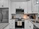 Bright kitchen with white cabinets, granite countertops, stainless steel appliances, and island at 720 4Th St, Stanley, NC 28164