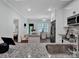 Bright kitchen featuring white cabinets, granite counters, stainless steel appliances, and open layout to dining area at 720 4Th St, Stanley, NC 28164