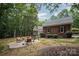 Scenic backyard with a patio, swing, brick siding, lush greenery, and a tranquil setting for outdoor enjoyment at 7408 Mockingbird Ln, Waxhaw, NC 28173