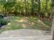 Expansive backyard with a stone patio and surrounding trees, perfect for relaxation and enjoying nature at 7408 Mockingbird Ln, Waxhaw, NC 28173