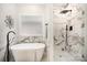 Spa-like bathroom featuring marble accents, a soaking tub, a separate shower and modern black fixtures at 7408 Mockingbird Ln, Waxhaw, NC 28173