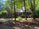 Charming two-story brick home with white trim, black shutters, and a cozy front porch in a wooded setting at 7408 Mockingbird Ln, Waxhaw, NC 28173