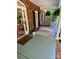 Inviting covered front porch featuring a swing, welcome mat, colorful flower pot and brick accents at 7408 Mockingbird Ln, Waxhaw, NC 28173