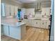 Open kitchen with white cabinets, stainless steel appliances, and hardwood flooring throughout at 7408 Mockingbird Ln, Waxhaw, NC 28173