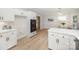 Bright kitchen boasts white cabinets and stainless appliances and quartz counters with modern lighting and eat-in dining area at 7408 Mockingbird Ln, Waxhaw, NC 28173