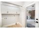 Convenient laundry room offers ample storage with white cabinets and a glimpse of the brick exterior through the door at 7408 Mockingbird Ln, Waxhaw, NC 28173