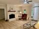 Inviting living room features a fireplace with white-painted brick, modern lighting, and wood flooring at 7408 Mockingbird Ln, Waxhaw, NC 28173