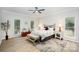 Spacious main bedroom features hardwood floors, a ceiling fan, and plenty of natural light from multiple windows at 7408 Mockingbird Ln, Waxhaw, NC 28173