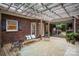Cozy backyard patio with wooden pergola, brick exterior, swing, and lush potted plants, great for outdoor gatherings at 7408 Mockingbird Ln, Waxhaw, NC 28173